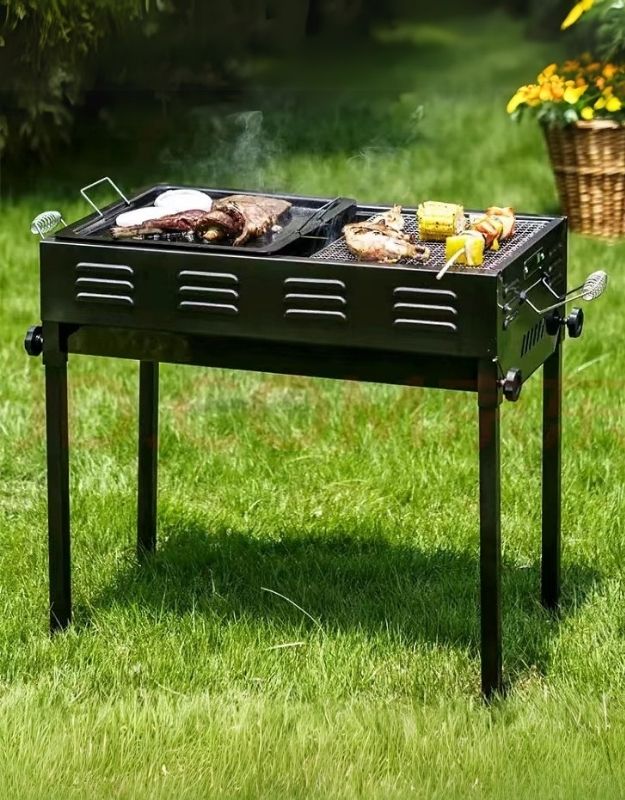 A portable charcoal BBQ grill with food being cooked on it, placed on a grassy outdoor area.
